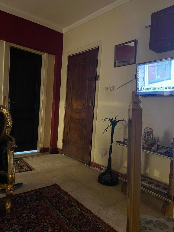 een woonkamer met een tv en een deur bij شقه مفروشه سوبر لوكس بميامى الاسكندريه in Alexandrië