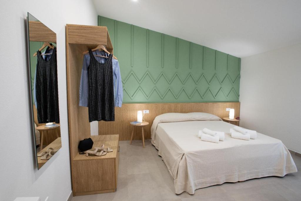 Schlafzimmer mit einem Bett und einem Spiegel in der Unterkunft Tarsis Guest House in Baunei