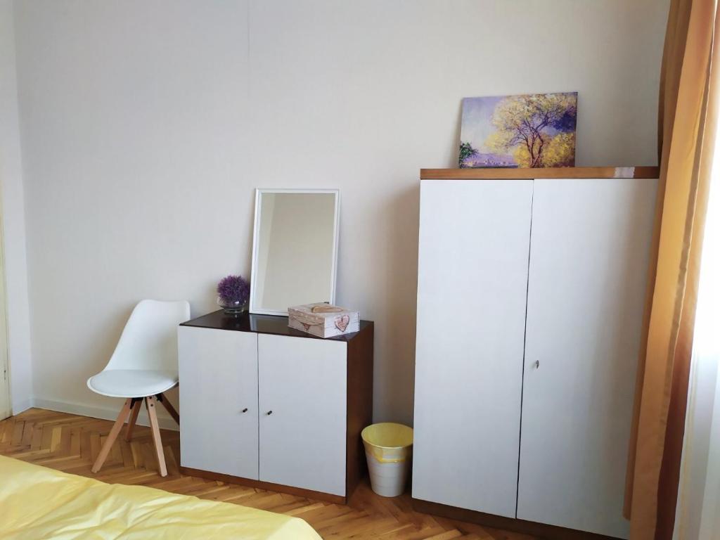a bedroom with two white cabinets and a mirror at Lidda Apartment in residential area in Varna City