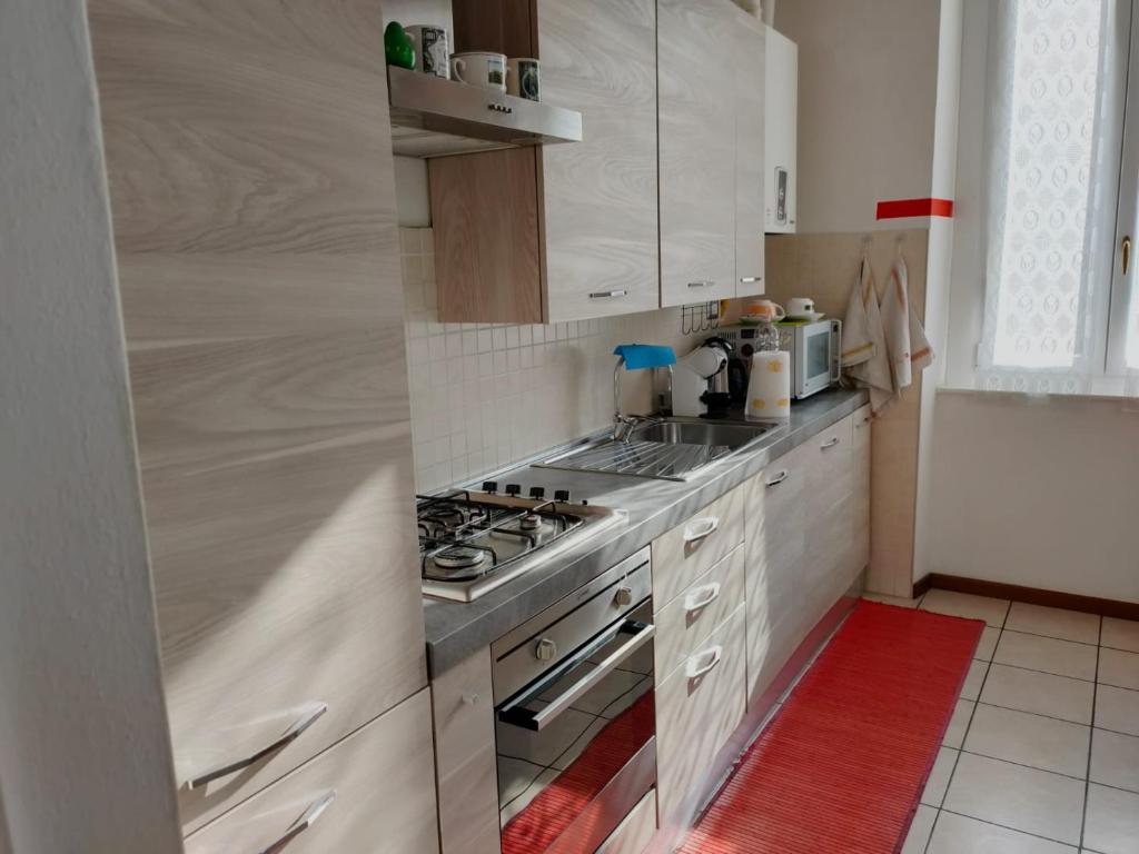 uma cozinha com armários brancos e um forno com placa de fogão em B&B Villa Hope em Malnate