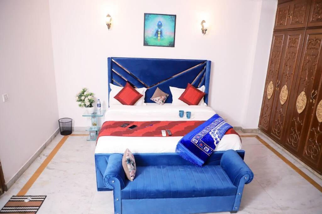 1 dormitorio con cama azul y almohadas rojas en Fortune Home Service Apartment,2Bhk, D-198,SAKET en Nueva Delhi