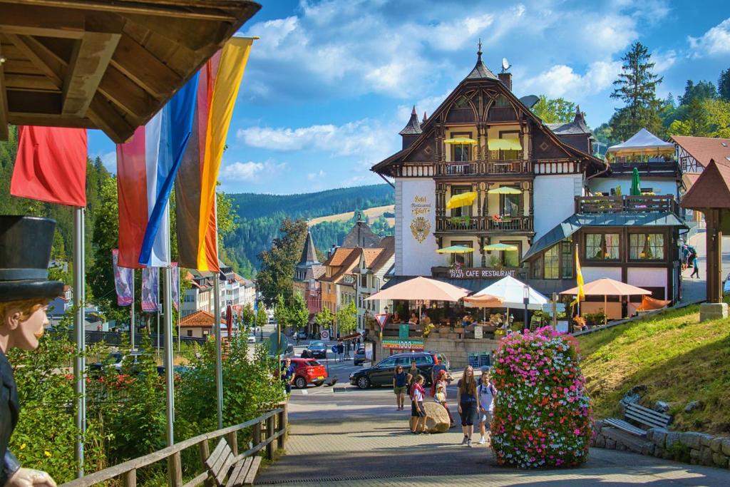 a town in the mountains with people walking down a street at Hotel Pfaff in Triberg