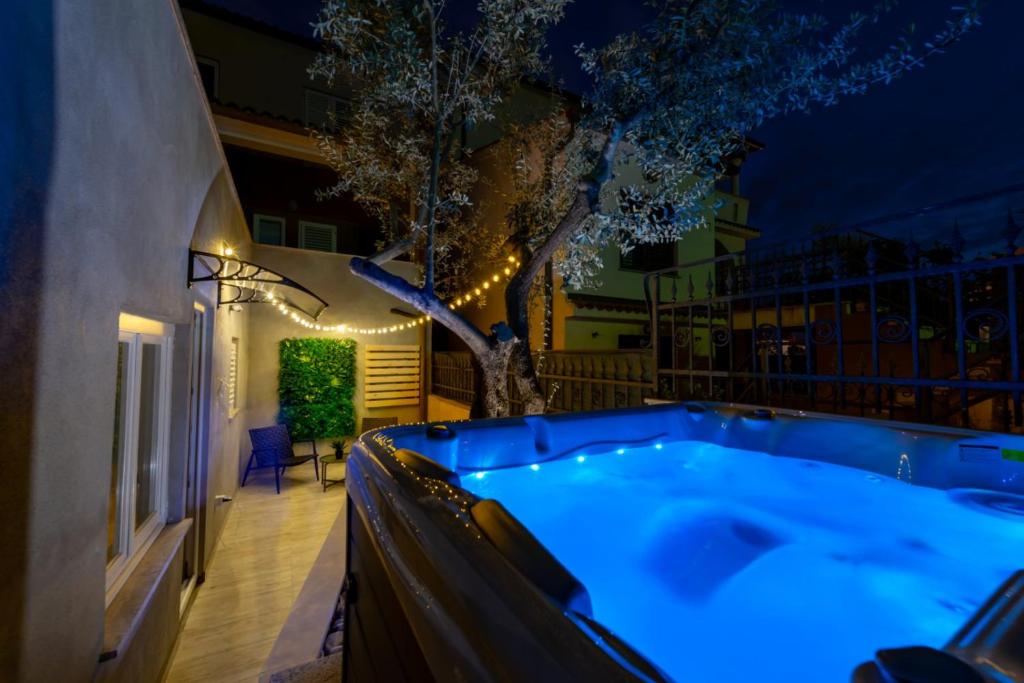 a hot tub in a backyard at night at Studio Apartment Mare with private garden and jacuzzi in Vinkuran