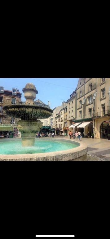 une fontaine au milieu d'une ville avec des bâtiments dans l'établissement Charmant logement proche Disneyland Paris parking, à Lagny-sur-Marne