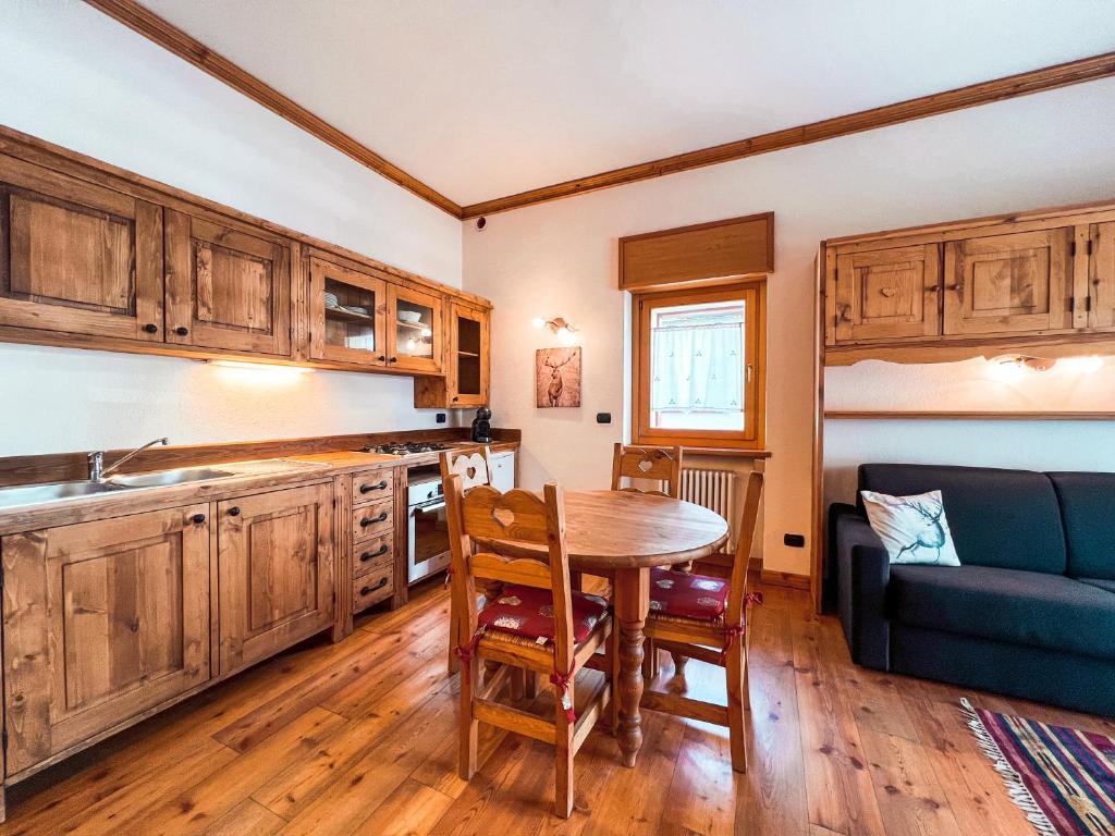 a kitchen with a table and a blue couch at Green Park Studio Courmayeur in Courmayeur