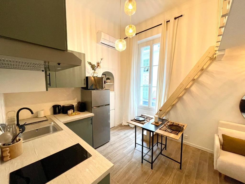 - une cuisine avec un évier et une table dans une chambre dans l'établissement COSY COCOON - 2 to 4 travelers., à Nice