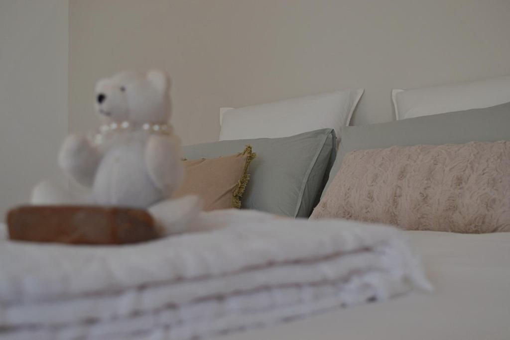 un orsacchiotto seduto sopra un letto di Chambre d'hôte au Domaine Terre de Chênes a Saint-Paul-de-Baïse
