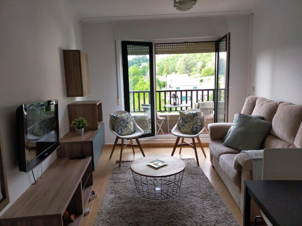 een woonkamer met een bank en een tv bij ATICO CALDAS in Caldas de Reis