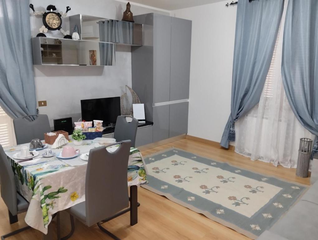 a dining room with a table and blue curtains at Casa vacanze GATTO MATTO due in Manziana