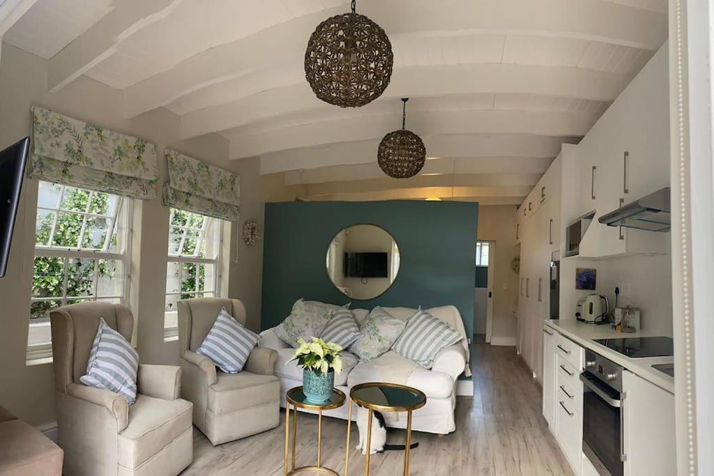 sala de estar con sofá blanco y mesa en Gorgeous, private cottage in prestigious Newlands. en Ciudad del Cabo