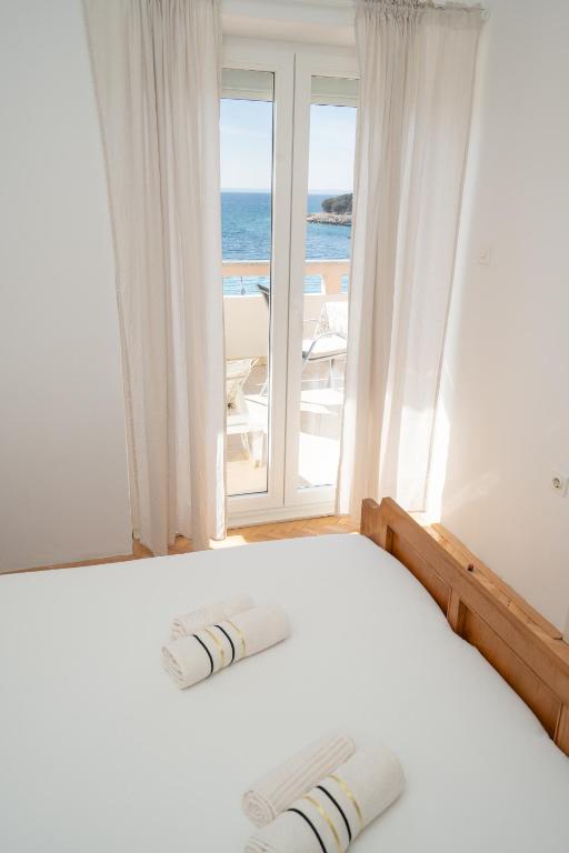 sypialnia z łóżkiem i widokiem na ocean w obiekcie Apartments and rooms LJUBICA w mieście Lun