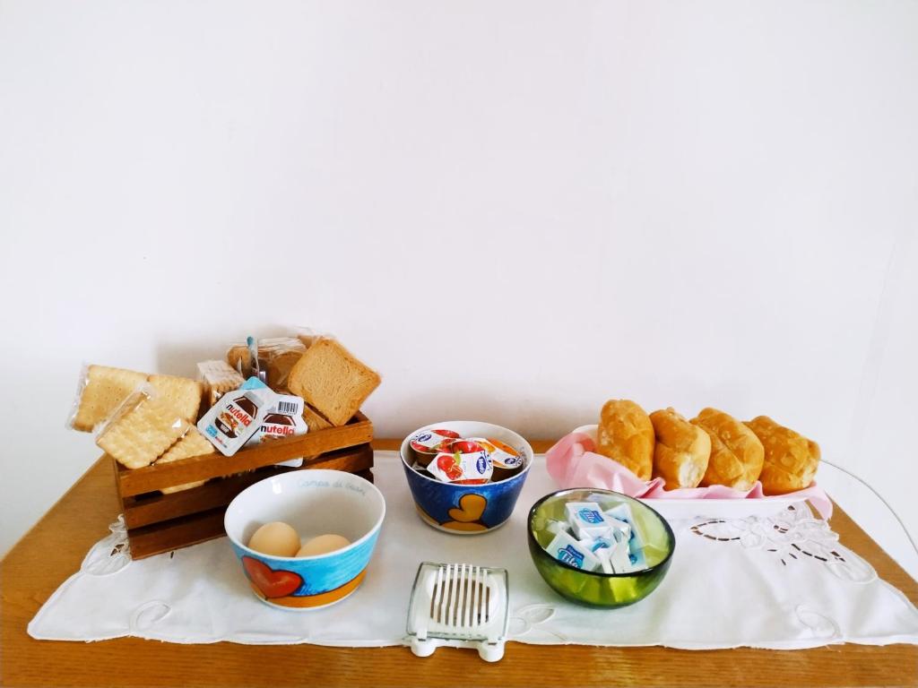una mesa con pan y otros alimentos. en BeB Le Masere, en Castel dellʼAlpi