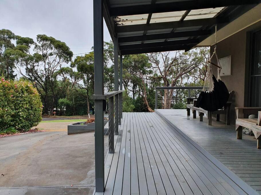 a porch with a hammock and benches on a house at Set amongst the treetops of Arthurs Seat in Arthurs Seat