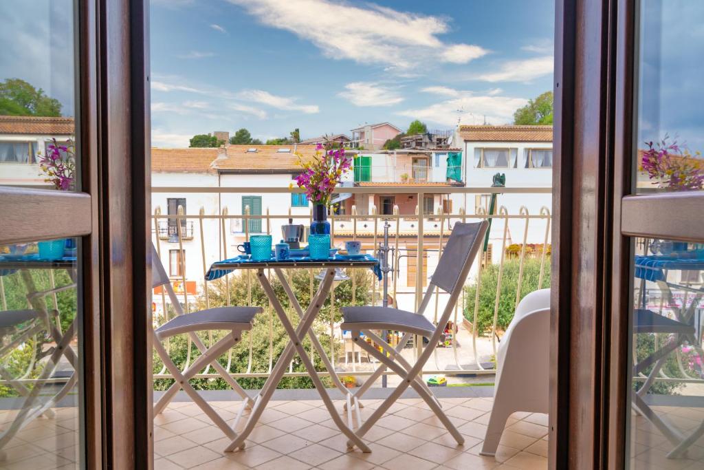 einen Tisch auf einem Balkon mit Blick auf ein Gebäude in der Unterkunft Appartamenti Letizia in Casal Velino