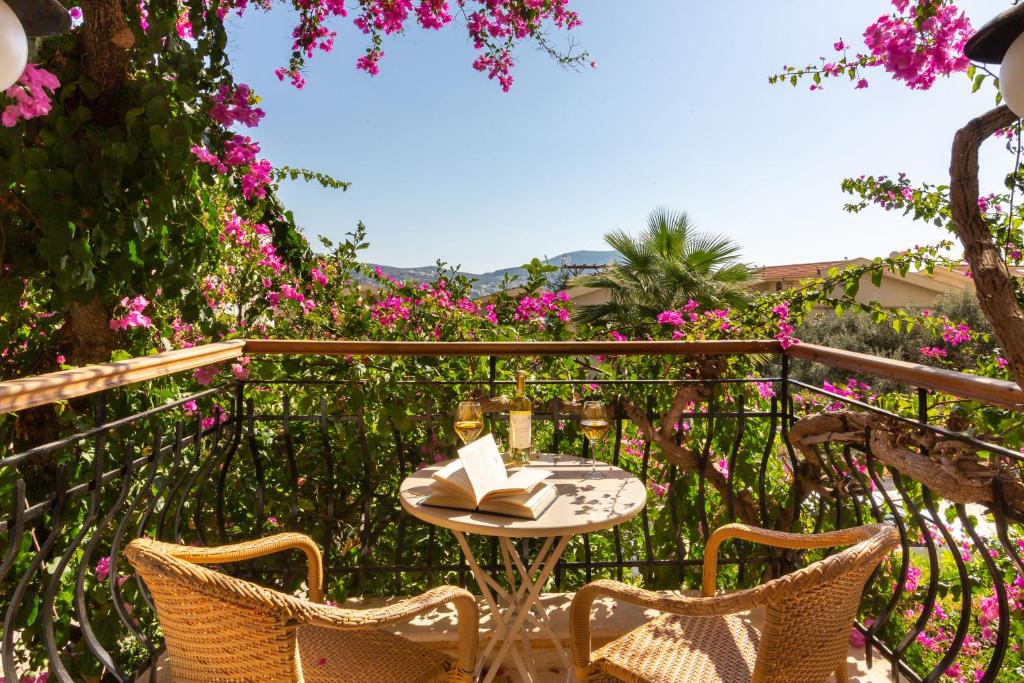 una mesa y sillas en un balcón con flores rosas en Korsan Apartments No:4, en Kas