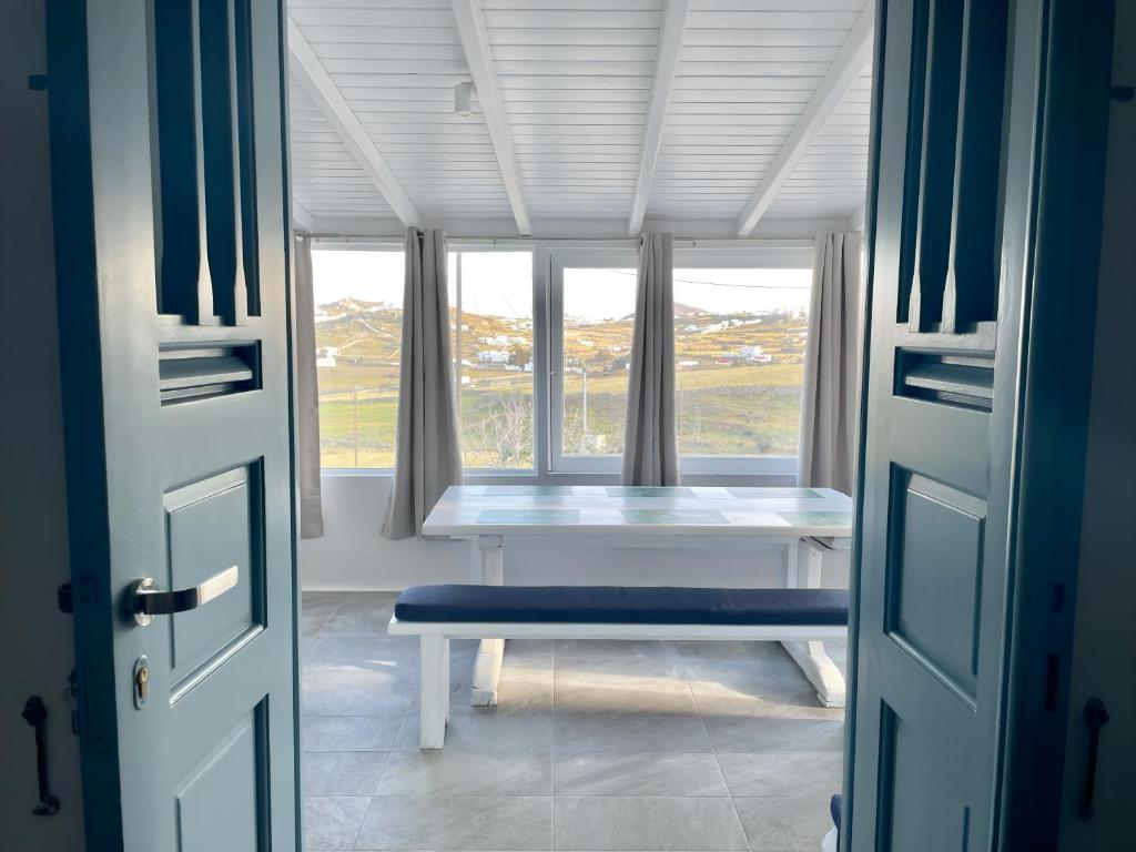 a room with a bench in front of a window at Black Pebble Myconian House in Ano Mera