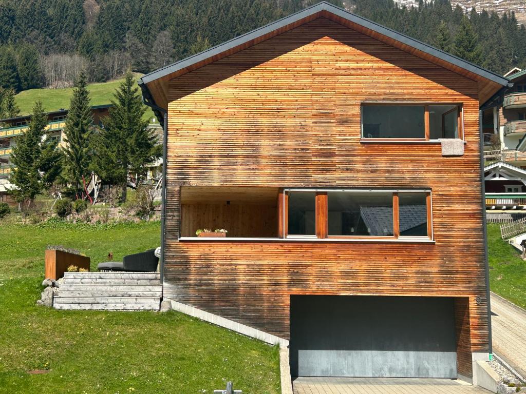 a brick house with a garage in a yard at hus9 in Mittelberg