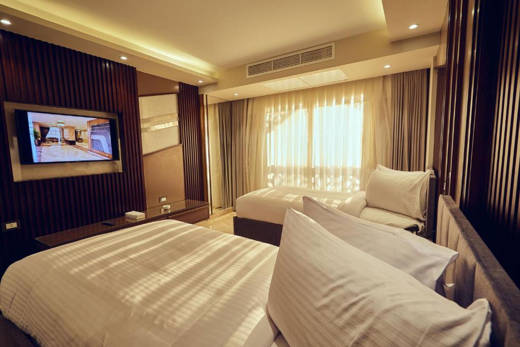 A bed or beds in a room at Grand Hotel Port Said