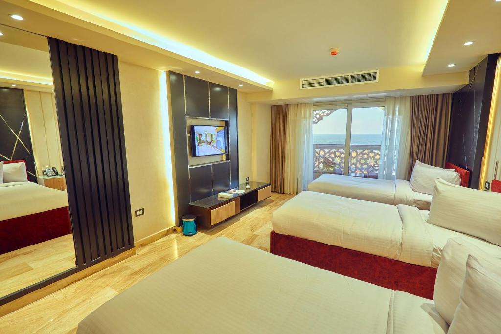 A bed or beds in a room at Grand Hotel Port Said