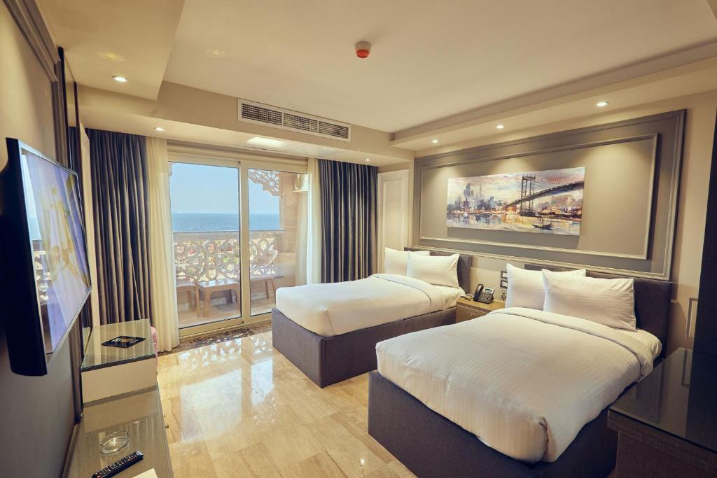A bed or beds in a room at Grand Hotel Port Said