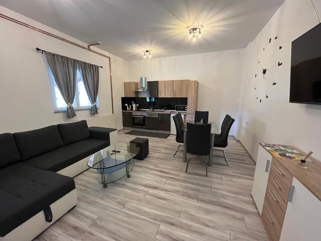 uma sala de estar com um sofá e uma mesa em Apartment Tilia em Otočac