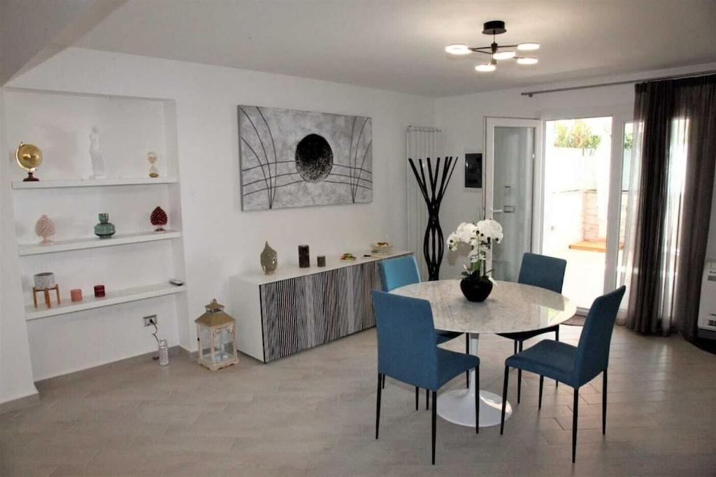ein Esszimmer mit einem Tisch und blauen Stühlen in der Unterkunft Vampolieri luxury home in Aci Catena