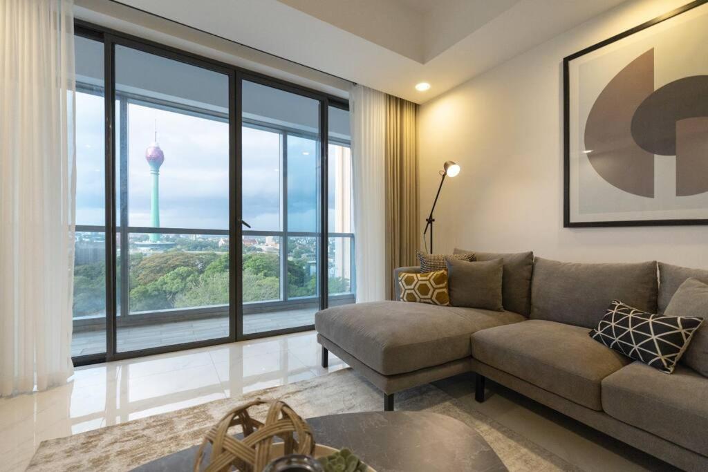 a living room with a couch and a large window at Twin Peaks residence in Colombo