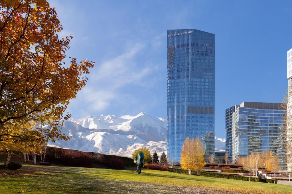 uma pessoa em pé num parque com vista para uma montanha em The Ritz-Carlton, Almaty em Almaty