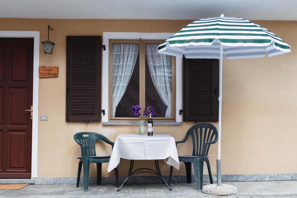 einen Tisch mit 2 Stühlen und einem Sonnenschirm in der Unterkunft Casa Celestino in Trarego Viggiona