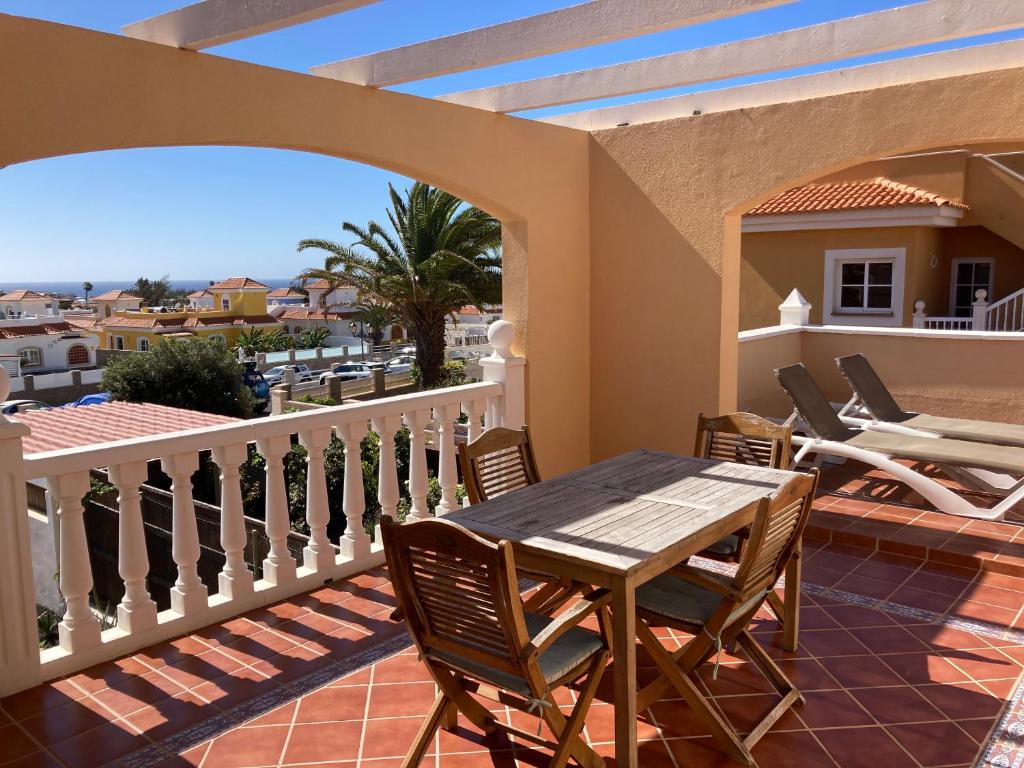 a patio with a table and chairs on a balcony at Las Rocas Golf and Sea in Caleta De Fuste