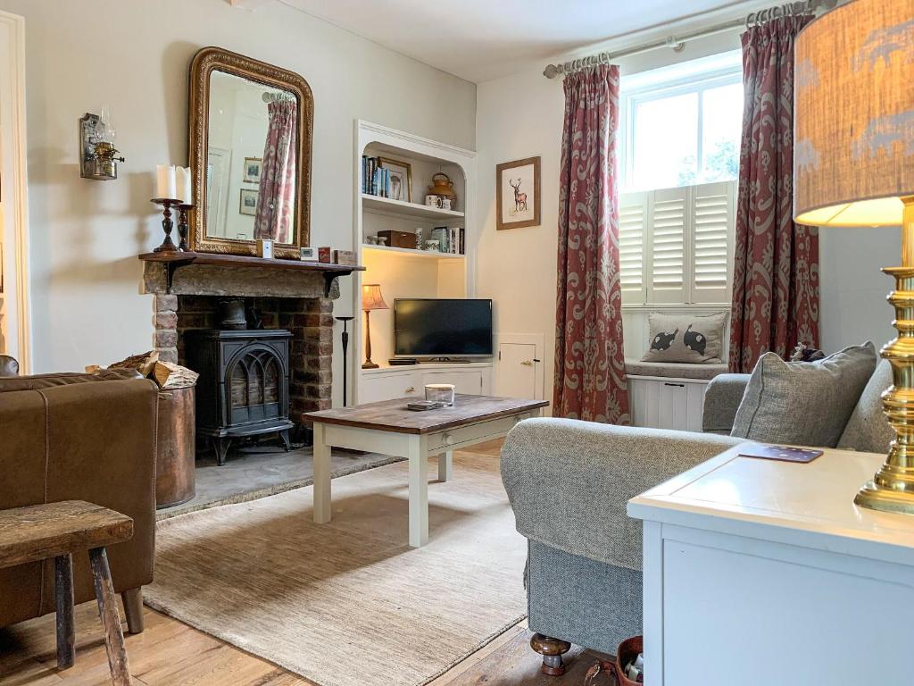 a living room with a fireplace and a television at Cherry Cottage in Gargrave