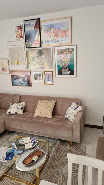 a living room with a couch and pictures on the wall at Appartamento GIRASOLE, Salò in Salò