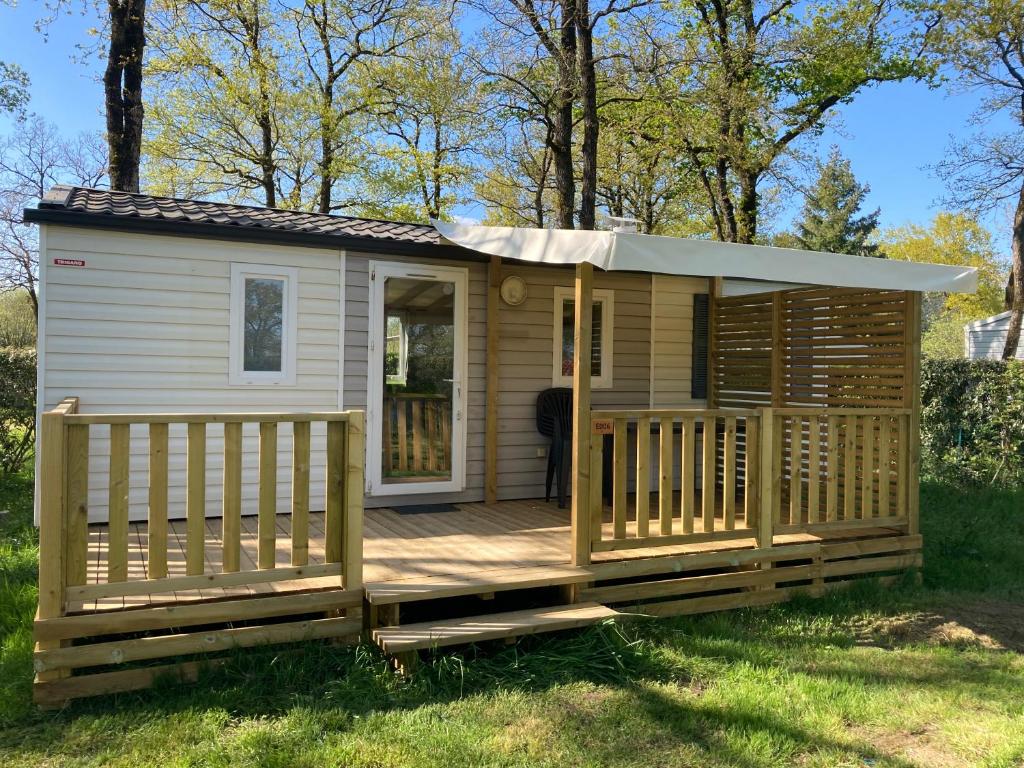 a wooden cabin with a porch and a deck at Mobile home 3 chambres Camping Cœur de Vendée 3 étoiles in La Boissière-de-Montaigu