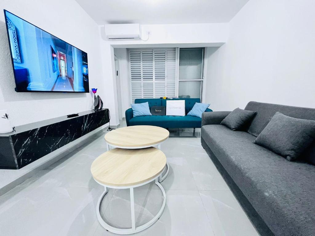 a living room with a couch and a table and a tv at New! Your home in Israel Luxury Suite in Bat Yam