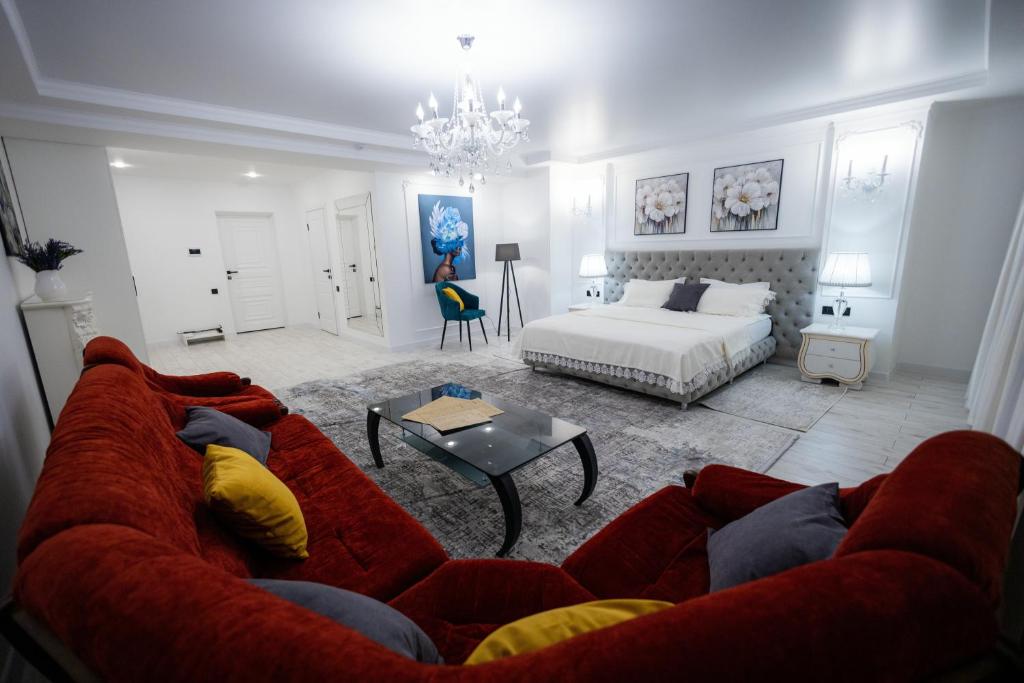 Metelitsa Hotel في كاراغاندي: غرفة معيشة مع أريكة حمراء وسرير