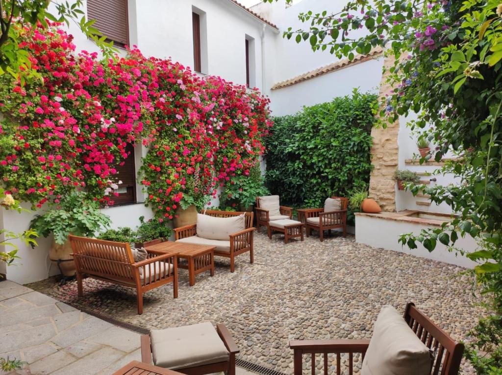 a patio with chairs and flowers on a building at ALHAJAS DE CORDOBA in Córdoba