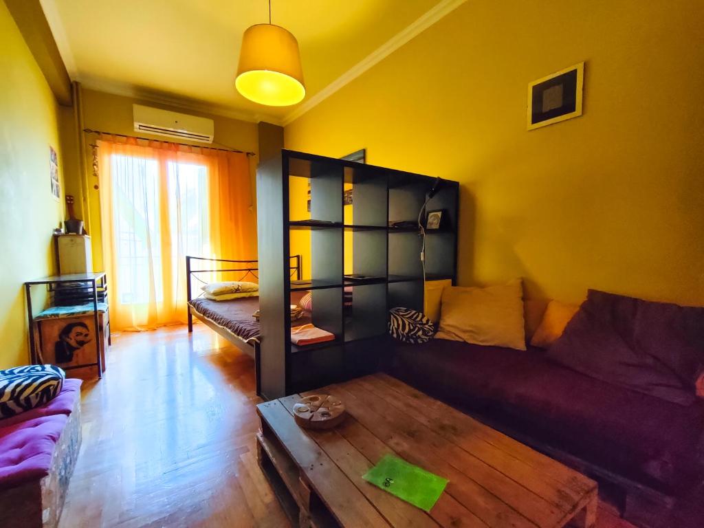 ein Wohnzimmer mit einem Sofa und einem Tisch in der Unterkunft Studio in Athens center in Athen