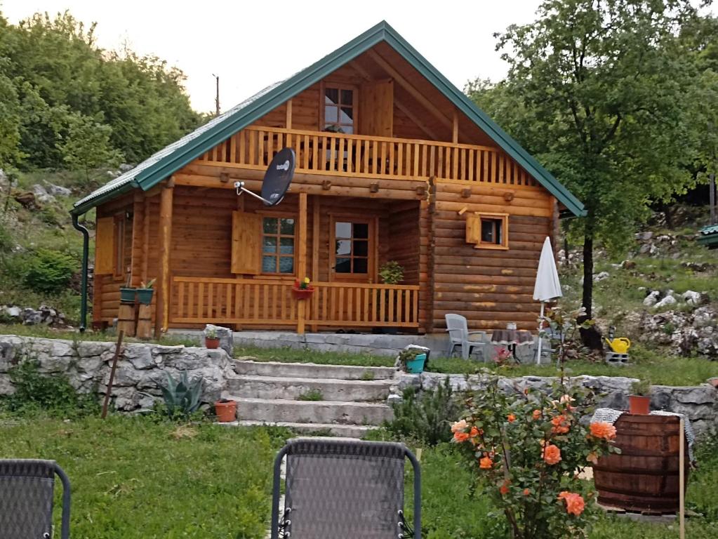 a log cabin with a porch and chairs in front of it at Bellavista 