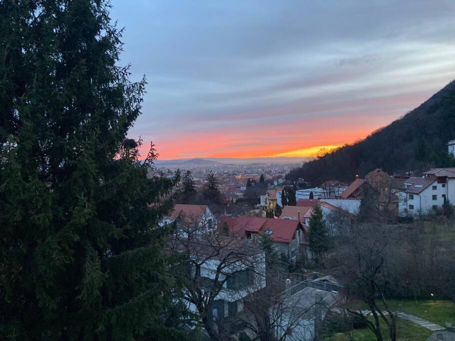 a view of a city with the sunset in the background at Evergreen Condo in Braşov