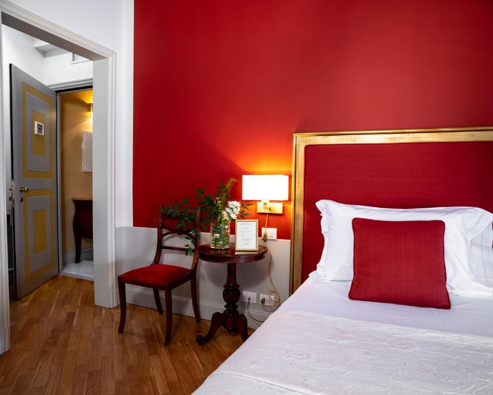 ピエトラサンタにあるAlbergo Pietrasantaの赤い壁のベッドルーム(ベッド1台付)
