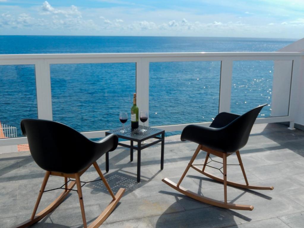 duas cadeiras e uma mesa numa varanda com o oceano em Beachhouse with amazing terrace next to the ocean em Bocacangrejo