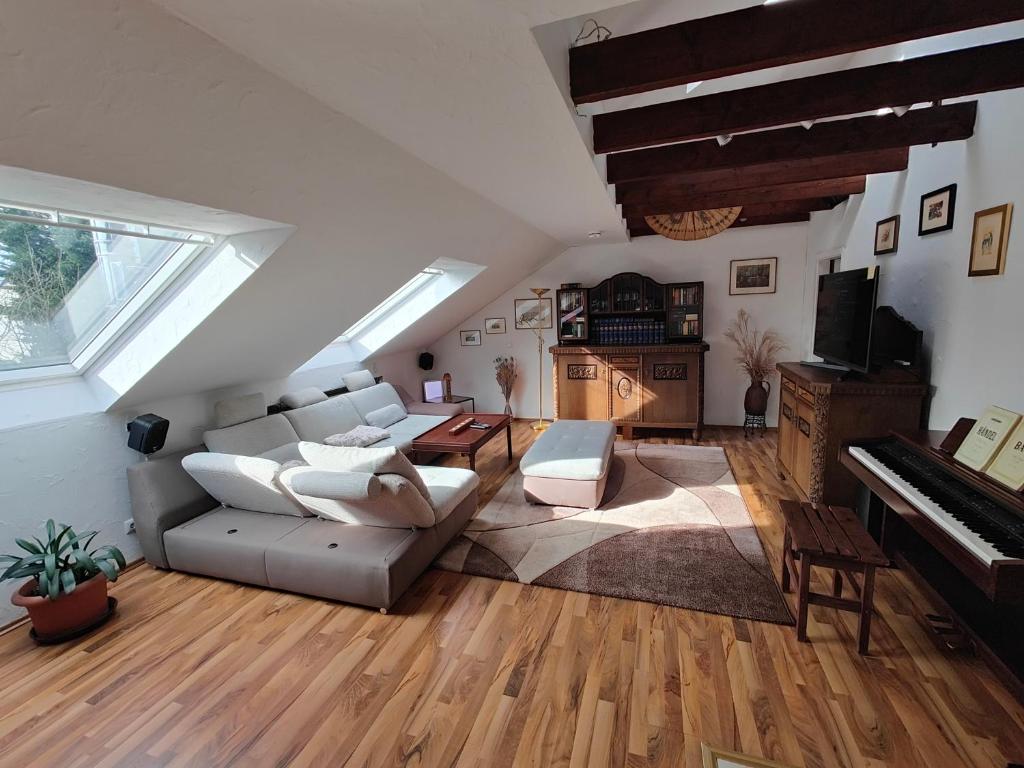 a living room with a couch and a piano at Luxuriöse Ferienwohnung, Vorort von Saarbrücken in Saarbrücken