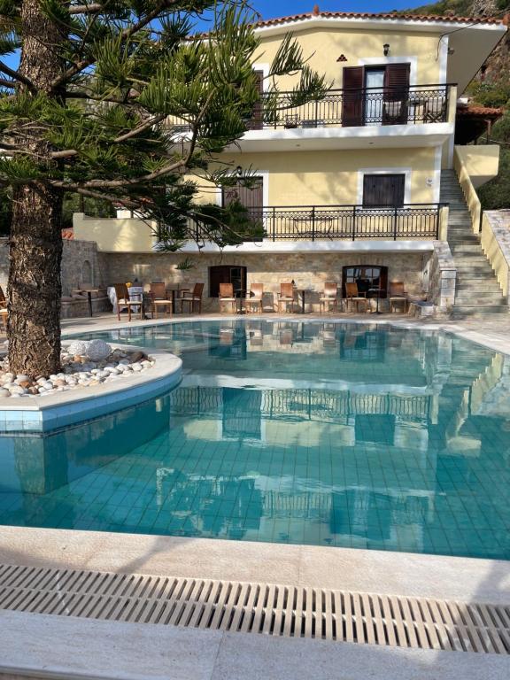 a swimming pool in front of a villa at LITHOS by the sea in Neo Itilo