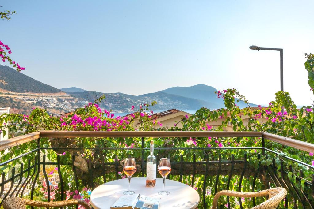 a table with two glasses of wine on a balcony at Korsan Apartment No.5 in Kaş