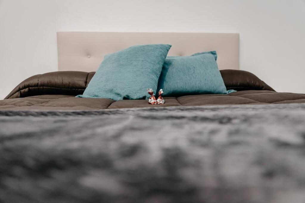 eine braune Couch mit blauen Kissen auf einem Bett in der Unterkunft Casa Lavanda in Villena