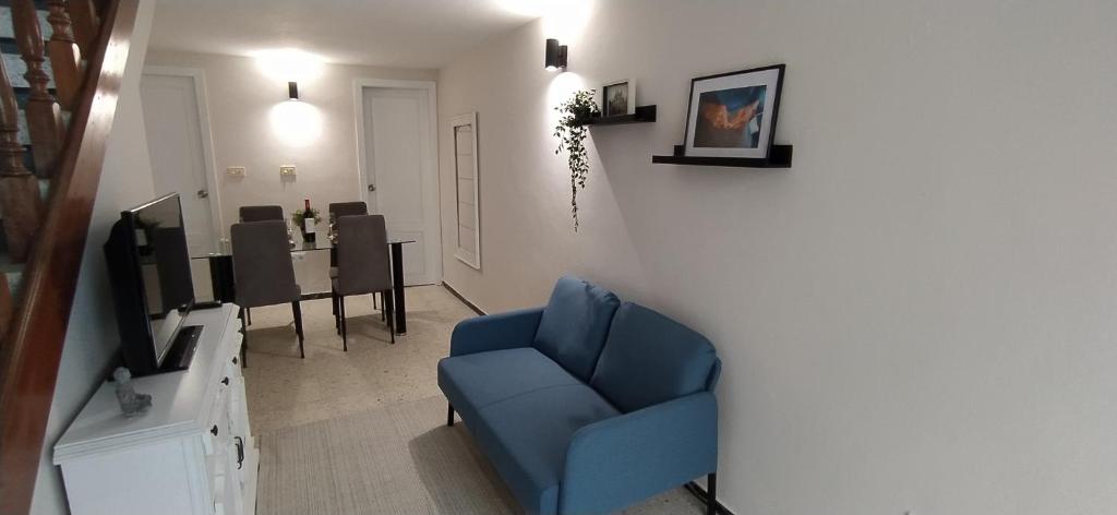 sala de estar con silla azul y comedor en Casa Peregrina, en Ourense