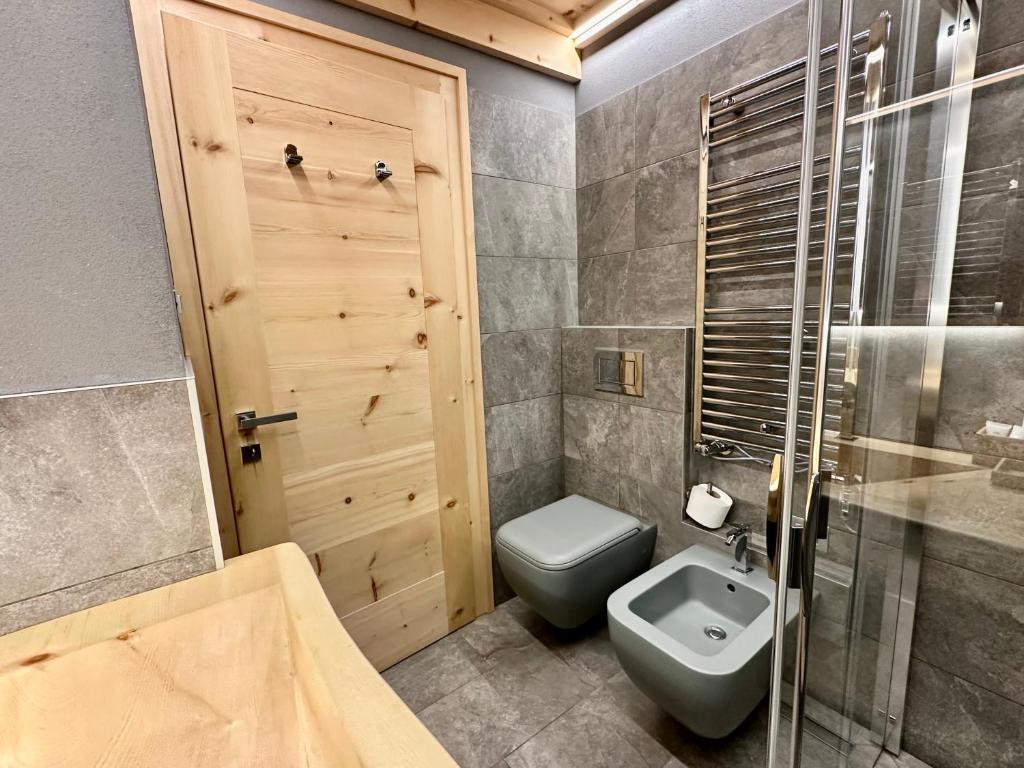 a bathroom with a toilet and a sink and a shower at Al Bait Del Legn 1 in Bormio
