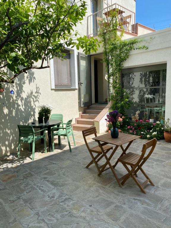 un patio con mesa y sillas frente a una casa en OtelUrla, en Urla