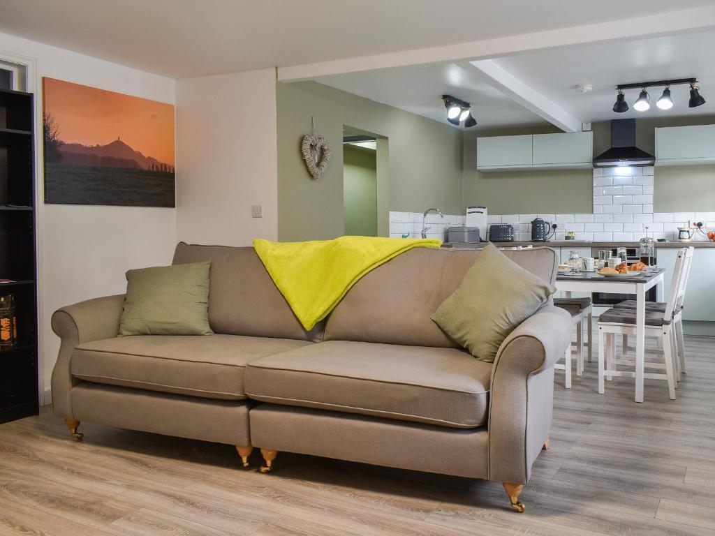 a couch with a yellow blanket on it in a kitchen at The Old Post House in Walton