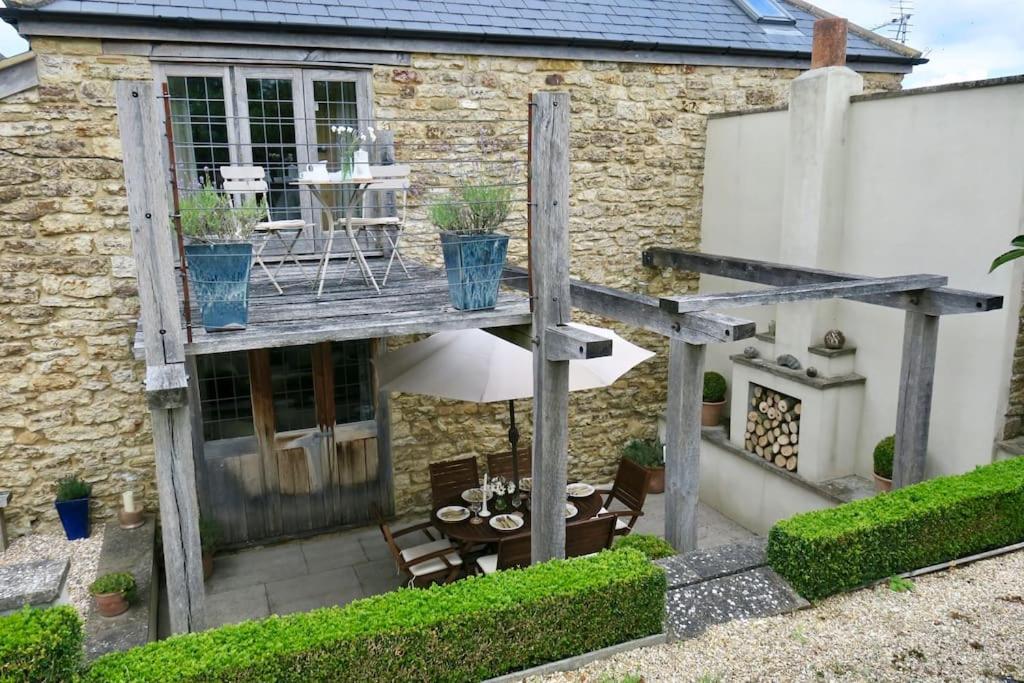 a patio with a table and chairs in front of a house at The Tallet - converted three bed stable - no children under 8 in Yeovil